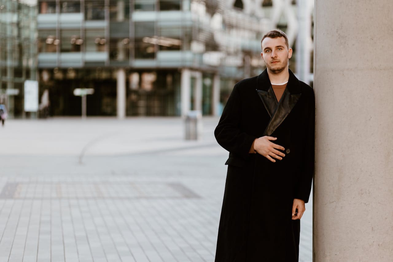 Man in a Coat Standing on the Sidewalk in City Man in a Coat Standing on the Sidewalk in City