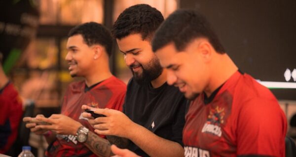 Three men playing mobile games together