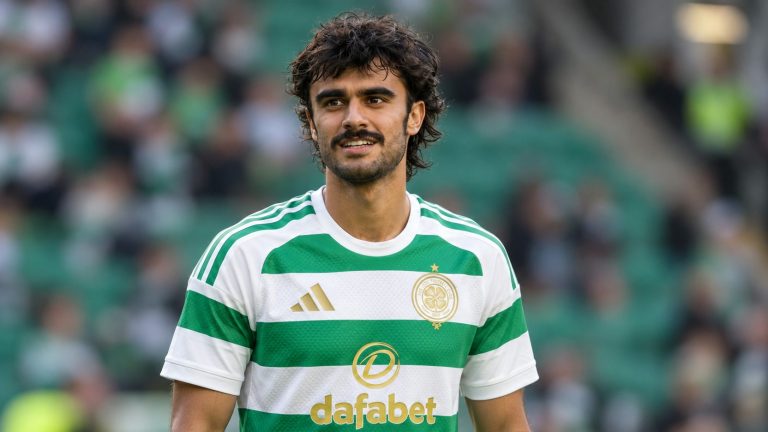 Jota wearing Celtic’s green-and-white hooped jersey at a football ground.