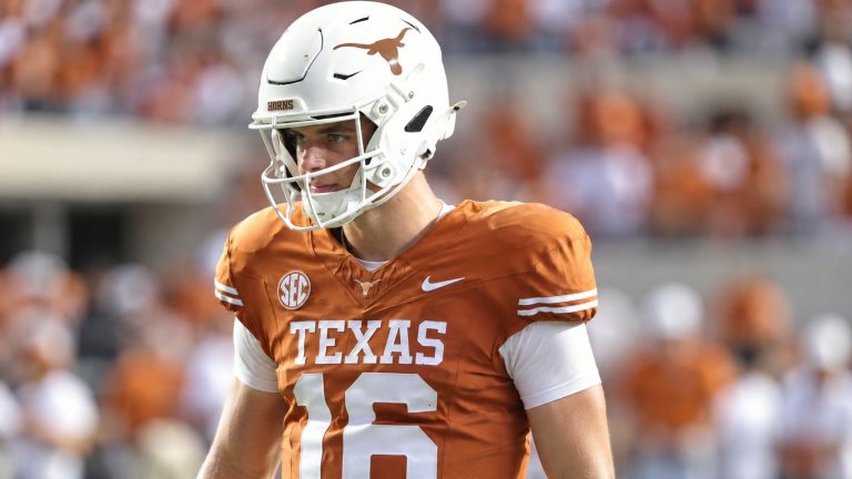 Arch Manning wearing a burnt-orange Texas No. 16 jersey and white Longhorns helmet on the field.
