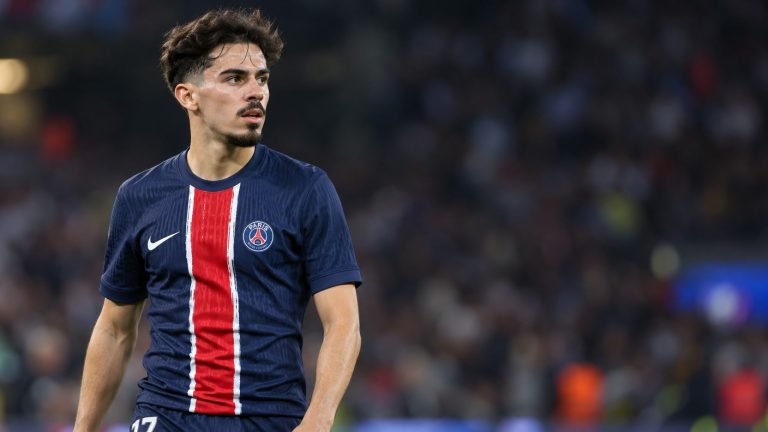 Vitinha wearing a navy Paris Saint-Germain shirt with a red central stripe.