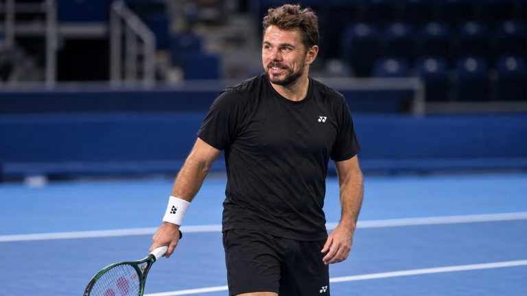 Stan Wawrinka in black Yonex training clothes holding a racket on an indoor hard court