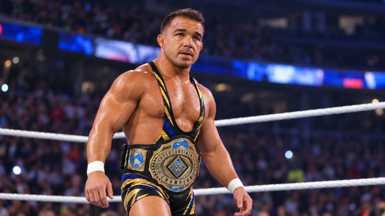 Chad Gable wearing a black, blue and gold singlet with the Intercontinental Championship around his waist in a wrestling ring