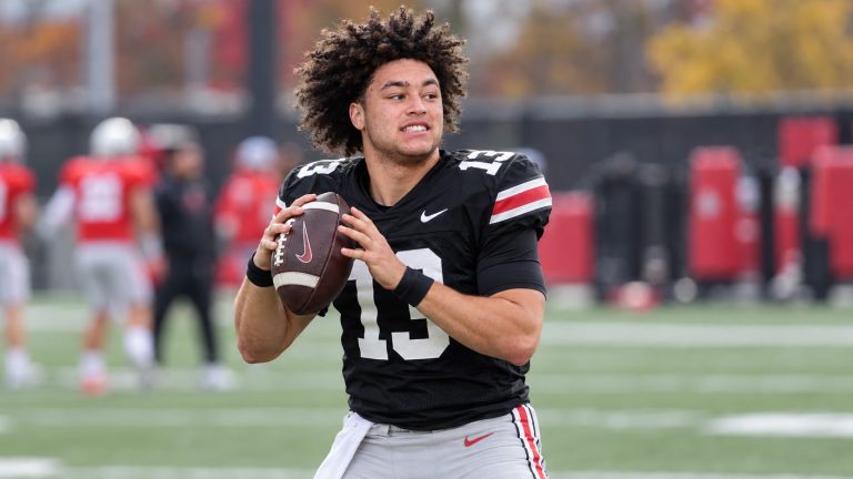 Luke Fahey in Ohio State’s black number 13 practice jersey holding a football on a practice field