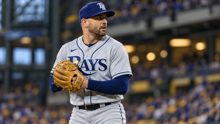 Nick Martinez in a gray Tampa Bay Rays uniform and navy cap holds his glove at his chest in a pitching set position.