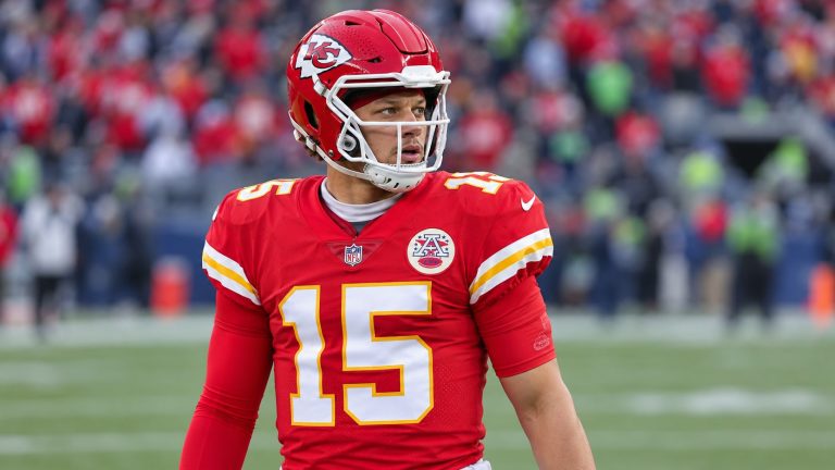 Patrick Mahomes wearing a red Kansas City Chiefs number 15 jersey and red helmet on a football field.