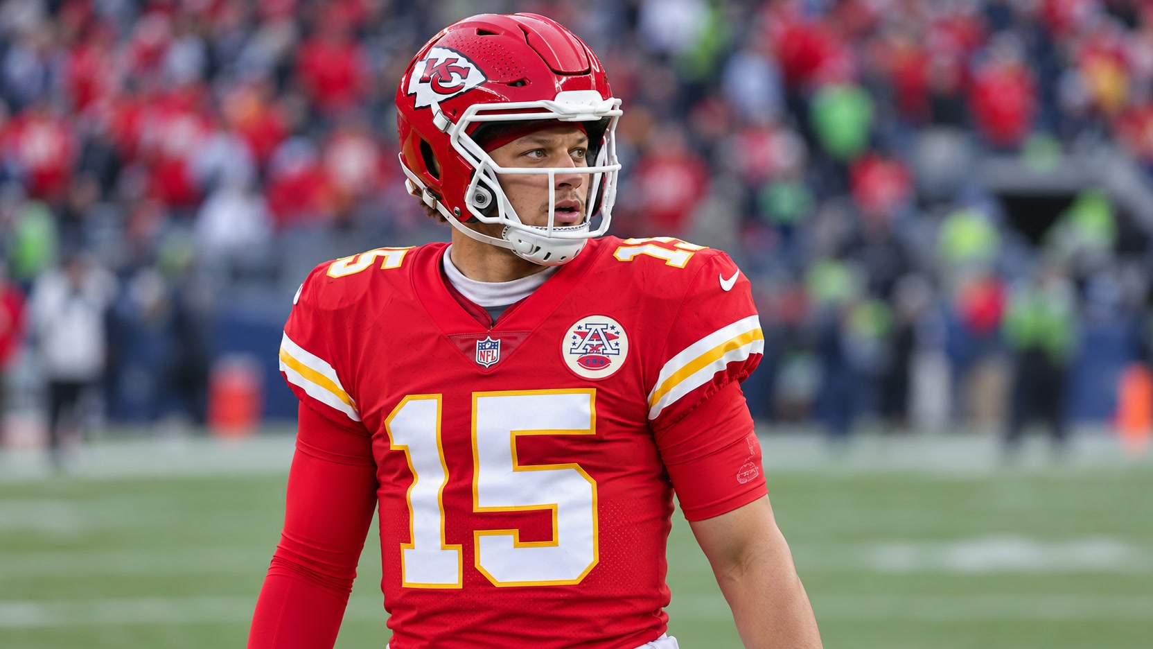 Patrick Mahomes wearing a red Kansas City Chiefs number 15 jersey and red helmet on a football field.