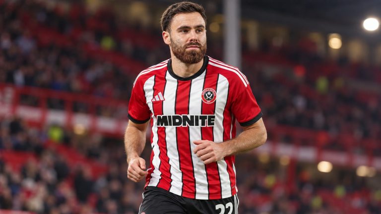 Ben Brereton Díaz jogging in Sheffield United’s red-and-white striped shirt and black number 22 shorts.